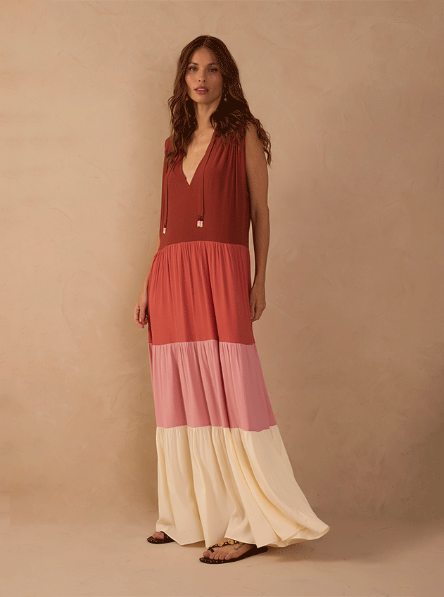 Shop by size M banner: woman in a sleeveless tiered maxi dress with terracotta, pink and cream colour blocks against a beige backdrop