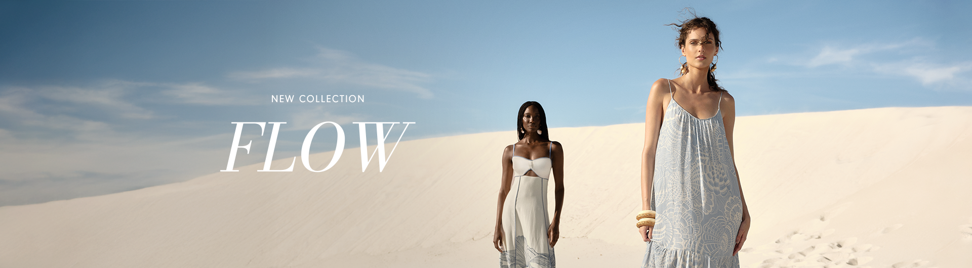 "New Collection FLOW" wide banner featuring two women in flowing white and light blue patterned dresses walking on sand dunes.