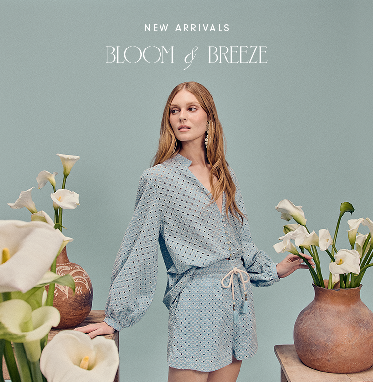 Dress To Bloom and Breeze new arrivals collection banner featuring a model in a light blue dotted dress surrounded by white calla lilies against a sage green background
