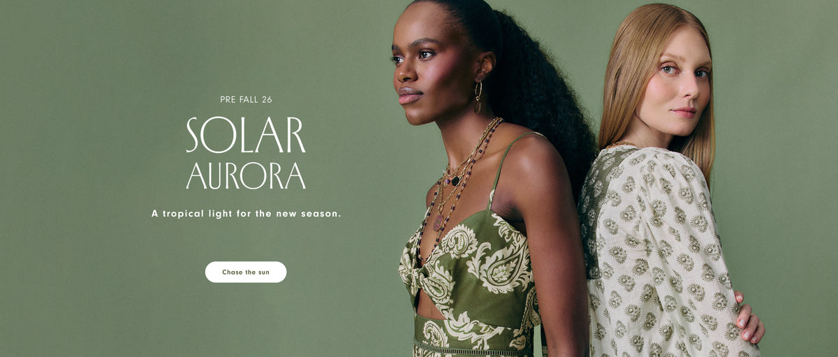 Pre Fall 26 Solar Aurora desktop campaign banner: two models standing back to back against a sage green background, one in an olive paisley-print cutout dress and the other in a cream floral-print blouse, with the tagline "A tropical light for the new season" and a "Chase the sun" button.
