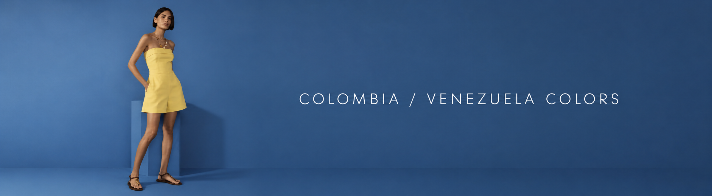Woman wearing a yellow strapless romper against a blue background with "Colombia / Venezuela Colors" text
