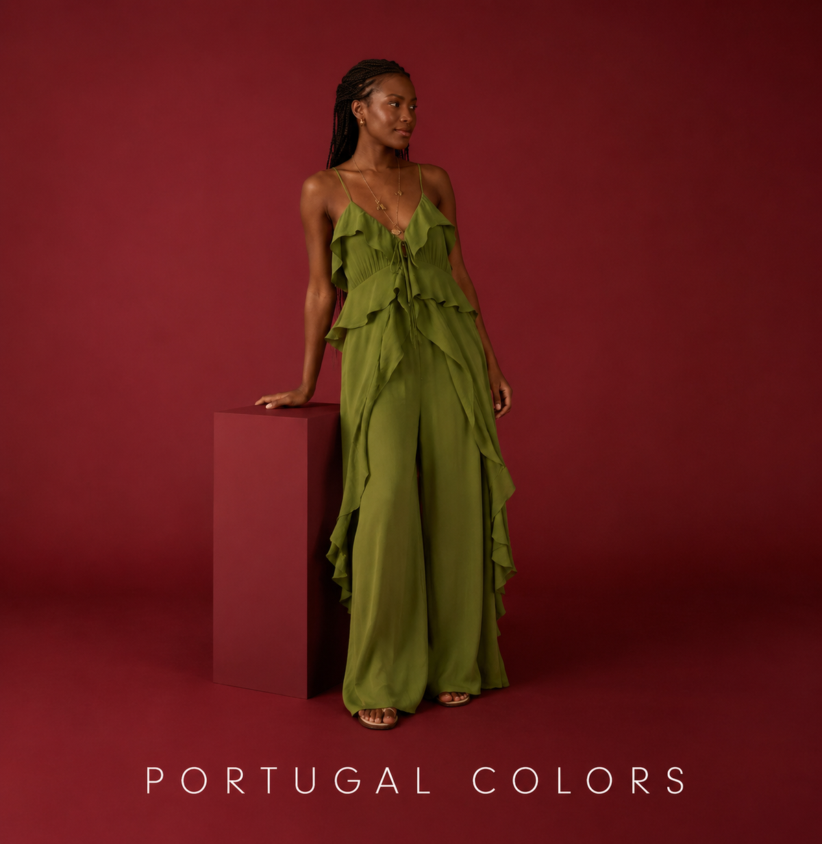 Woman wearing a green ruffled sleeveless maxi dress against a deep red background with "Portugal Colors" text