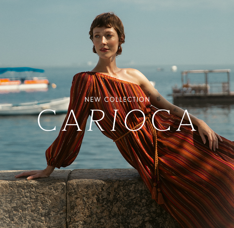 Mobile banner for the 'New Collection Carioca.' It features a close-up, vertical shot of a model in a reddish-orange flowing dress, posing near the water with the ocean and boats in the background.