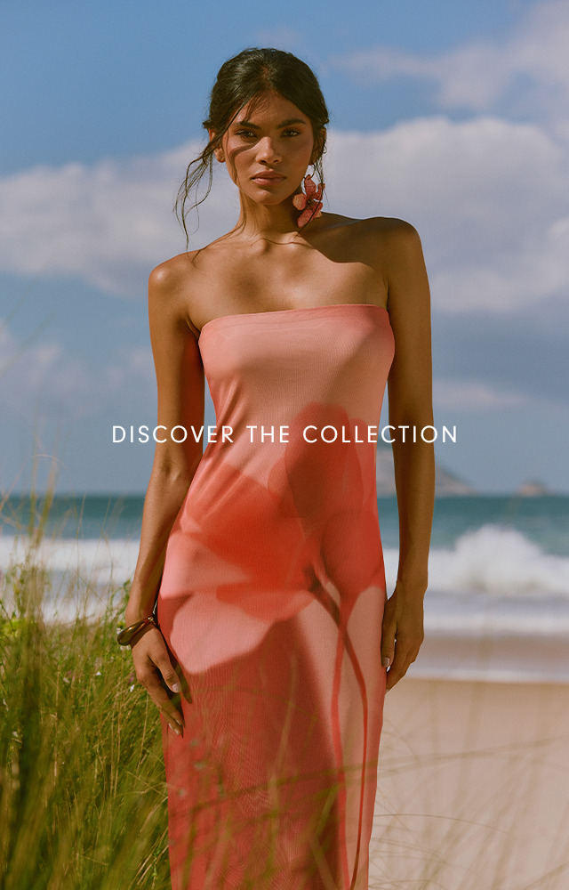 Vertical mobile lookbook banner with the text Discover the Collection, showing a model in a coral slip dress among beach grass by the sea