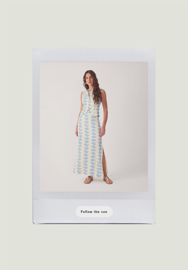 Dress To FLOW new arrivals mobile home page banner video, polaroid photo of woman wearing long sleeveless blue printed maxi dress and gold sandals, with Follow the sun call to action button on cream background