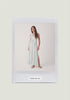 Dress To FLOW new arrivals mobile home page banner video, polaroid photo of woman wearing long sleeveless blue printed maxi dress and gold sandals, with Follow the sun call to action button on cream background