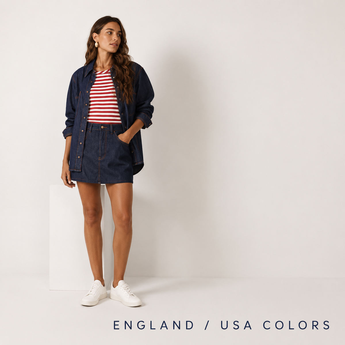 Woman wearing a denim jacket over a red and white striped top with a denim skirt and white sneakers against a cream background with "England / USA Colors" text
